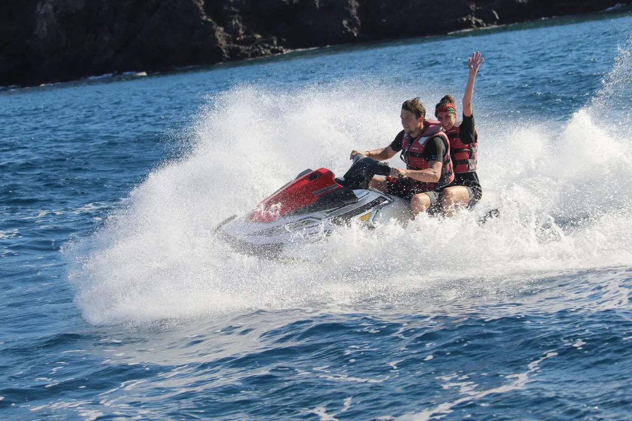 Riders and heavy spray against the cliffs